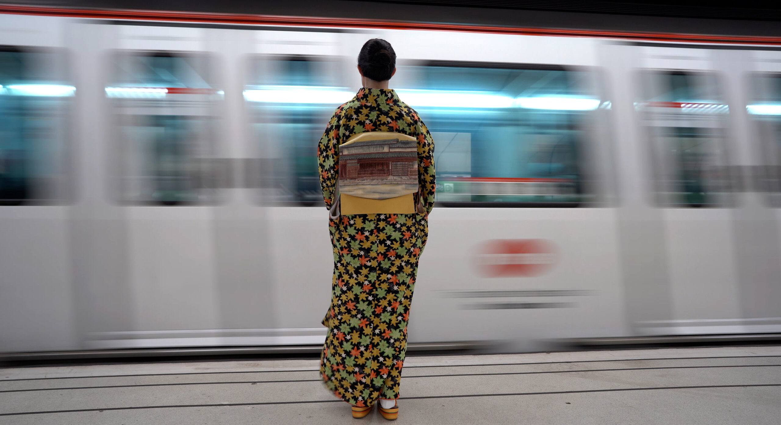 A woman wearing a kimono in the subway